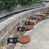 get back inc's - the original swing-out seats, outdoor bar stools for large social are attached to stone wall outdoor patio, very strong more durable than traditional seating, all made of steel and wood so longer lasting than standard bar stools