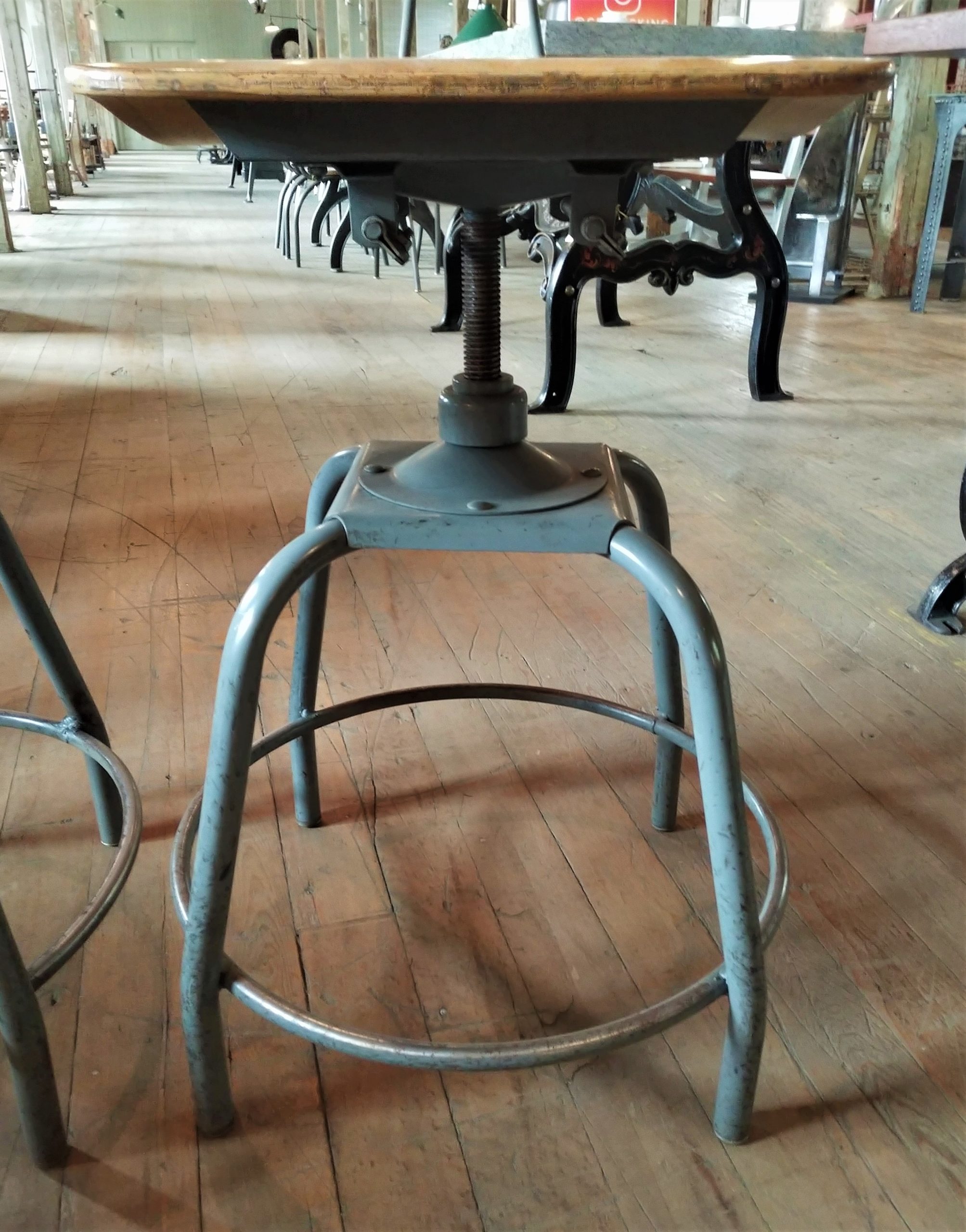fully adjustable early 1920's american vintage industrial four-legged  factory workbench stool with pre-drilled hole extensions